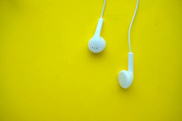 Earphones headset on yellow background , top view.