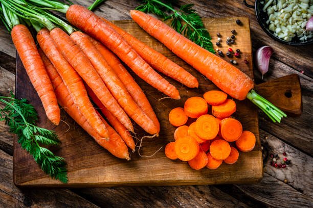 Overhead view of freshly sliced organic carrots on cutting board. High resolution 42Mp studio digital capture taken with Sony A7rII and Sony FE 90mm f2.8 macro G OSS lens